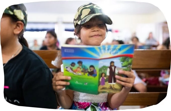 Kind liest in Broschüre Das größte Geschenk