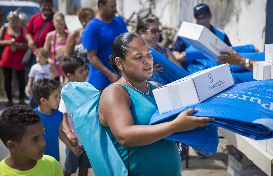 Eine Frau erhält von Samaritan's Purse ein Hilfspaket Eine Frau erhält von Samaritan's Purse ein Hilfspaket