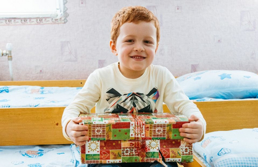 Junge freut sich über Geschenk von "Weihnachten im Schuhkarton"