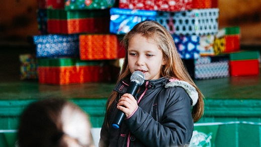 Ein Kind singt bei einer Weihnachtsfeier von "Weihnachten im Schuhkarton" Singendes Kind bei Weihnachten im Schuhkarton-Weihnachtsfeier