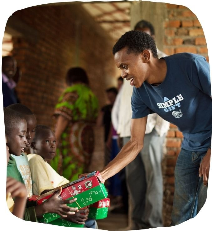 Alex übergibt Schuhkartons in Ruanda